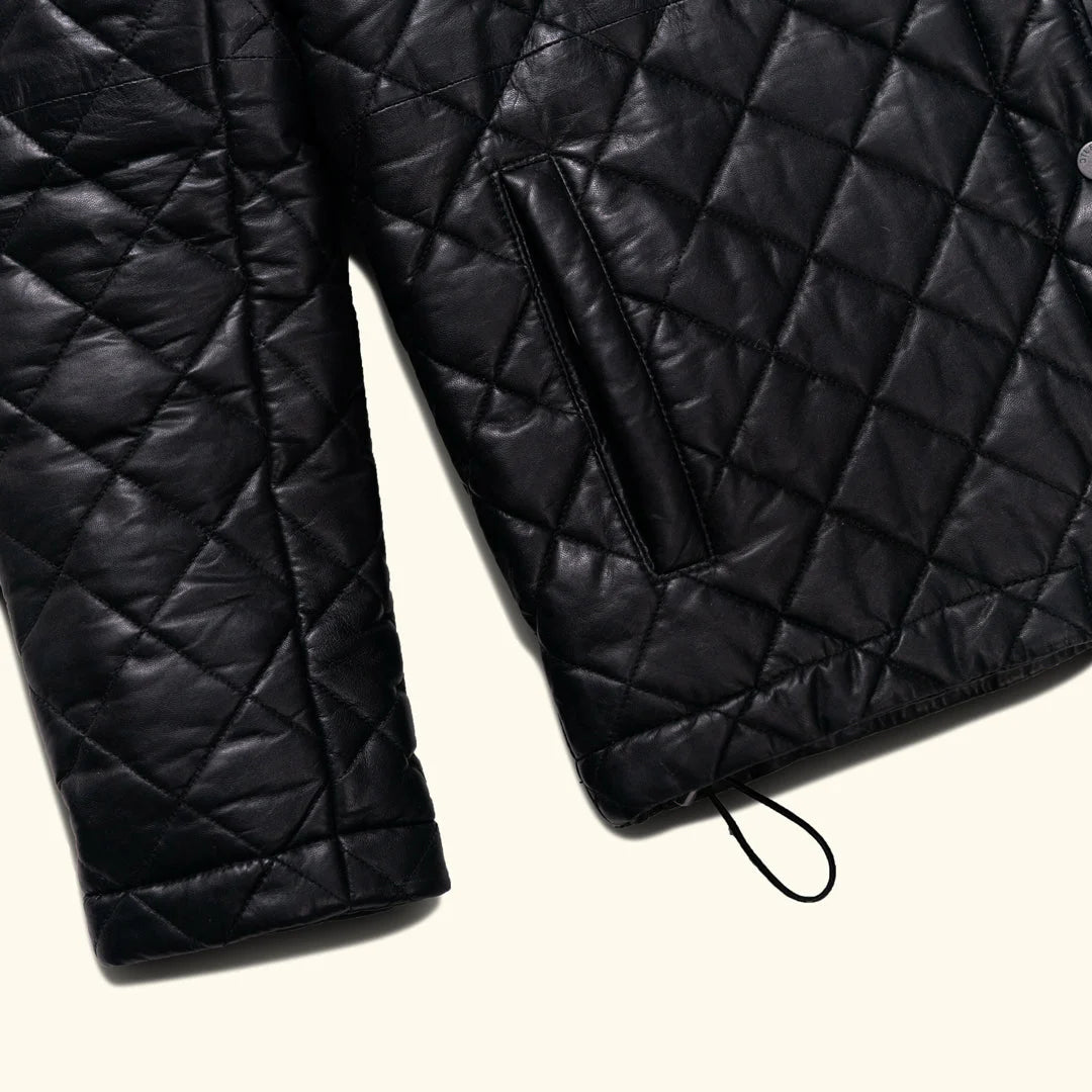 Black quilted jacket on a light beige background