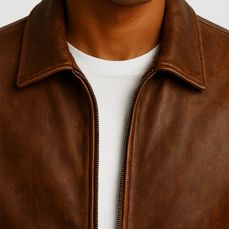 Brown leather jacket with a white shirt underneath on a light gray background