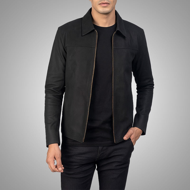 Man wearing a black jacket over a black shirt on a gray background