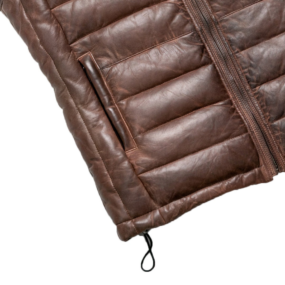 Close-up of a brown leather jacket with quilted design on a white background