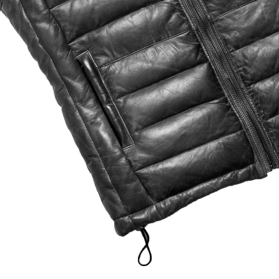 Close-up of a black quilted jacket with a zipper on a white background