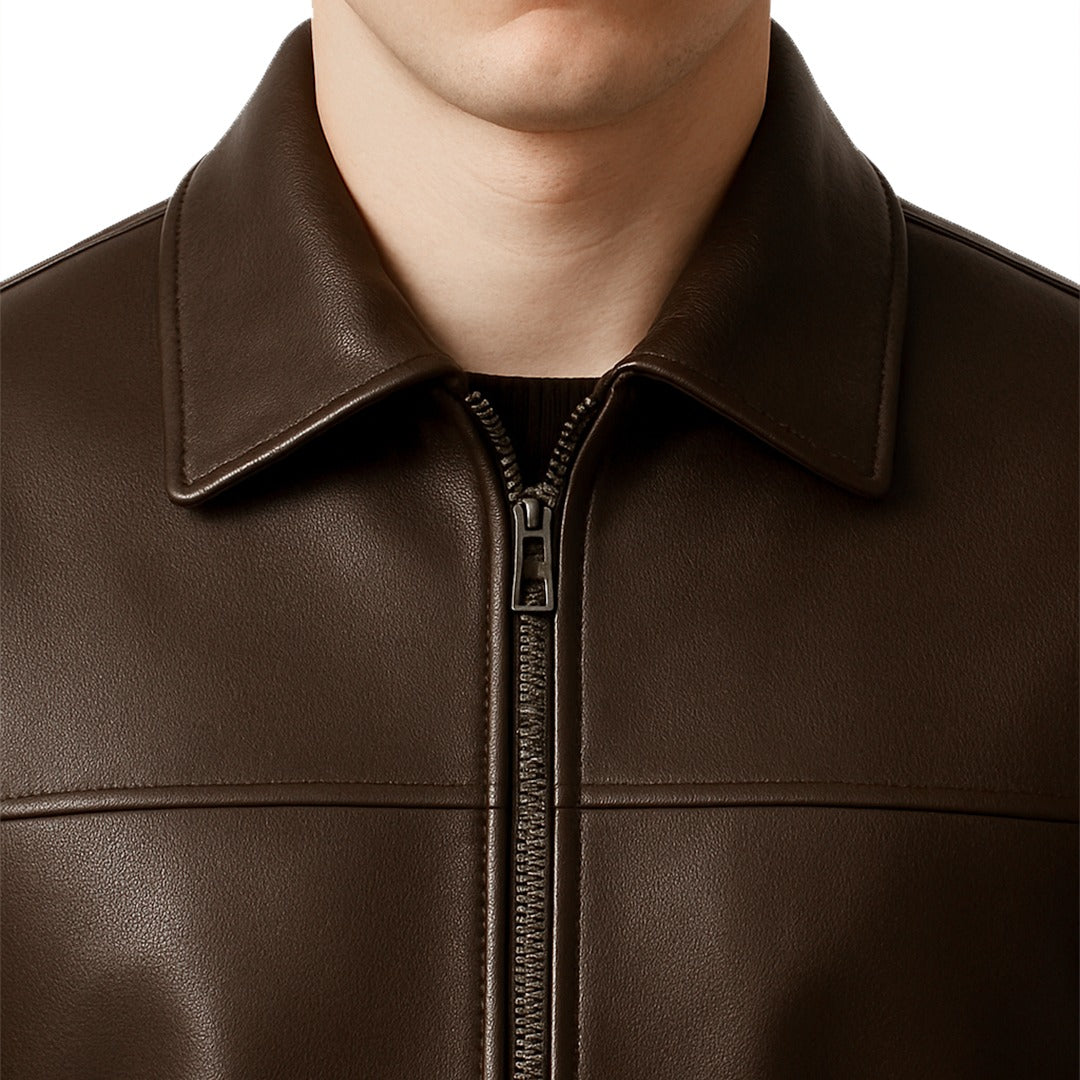 Close-up of a brown leather jacket with a zipper on a white background