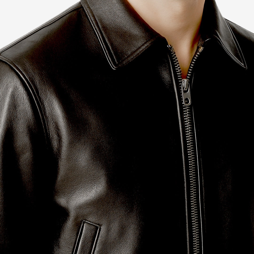 Close-up of a black leather jacket with a zipper