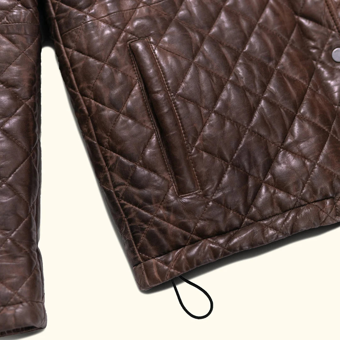 Close-up of a brown quilted jacket on a white background