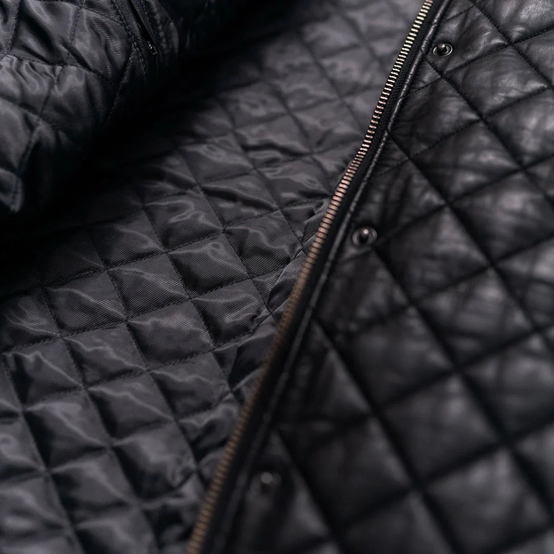 Close-up of a black quilted jacket with a zipper