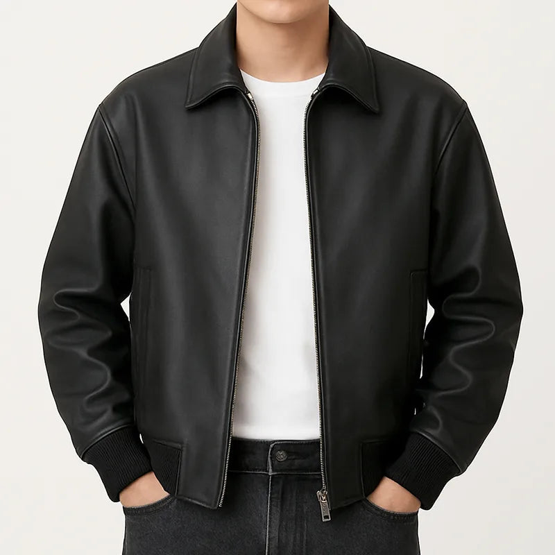 Person wearing a black jacket over a white shirt on a light gray background