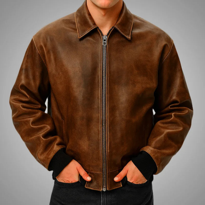 Brown leather jacket worn by a person on a gray background