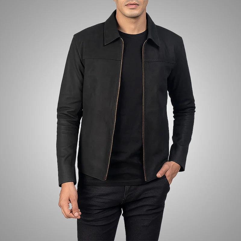 Man wearing a black leather jacket over a black shirt on a gray background