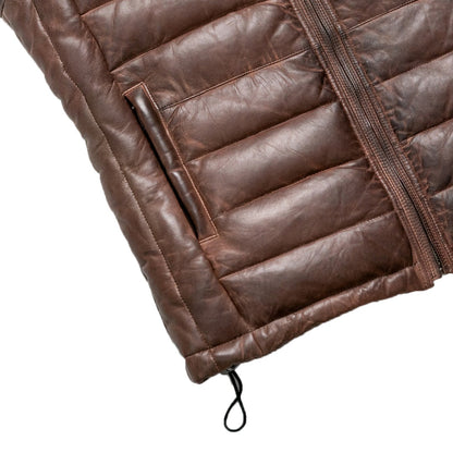 Close-up of a brown leather jacket with quilted design on a white background